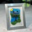 Work in fused glass representing a delicately carved tree, integrated into a colored or abstract background. Arbre No. 4 - Created by Stéphanie Béland - Percé-Verre.